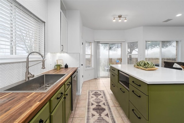 kitchen with green cabinetry, appliances with stainless steel finishes, a center island, and sink