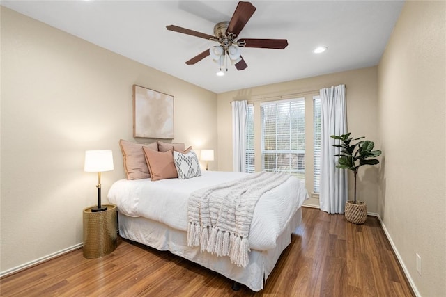 bedroom with dark hardwood / wood-style floors and ceiling fan