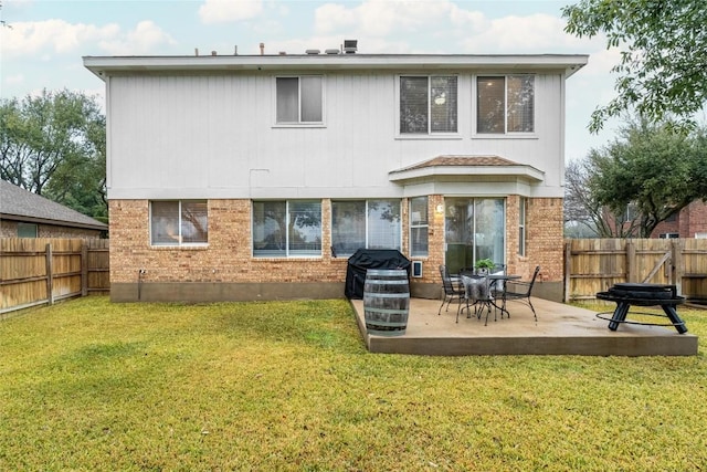 rear view of property with a yard and a patio area