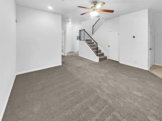 unfurnished living room with dark colored carpet and ceiling fan