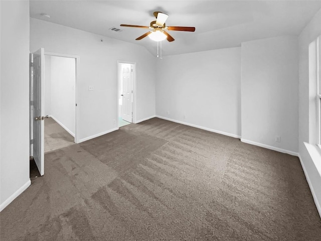 unfurnished room featuring dark carpet, vaulted ceiling, and ceiling fan