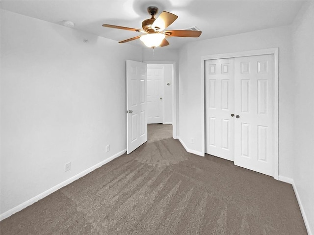 unfurnished bedroom featuring dark carpet, a closet, and ceiling fan