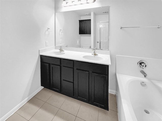 bathroom featuring vanity, a washtub, and tile patterned floors