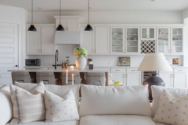 kitchen with decorative light fixtures, decorative backsplash, and white cabinets