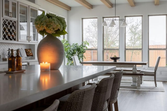 sunroom / solarium with beamed ceiling and a notable chandelier