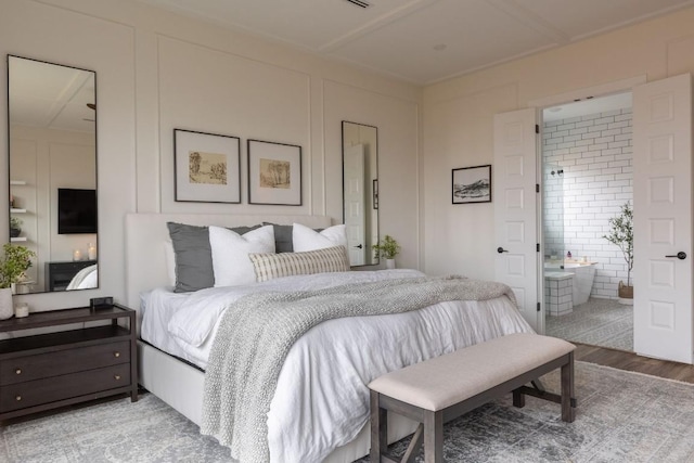 bedroom with wood-type flooring and ensuite bathroom