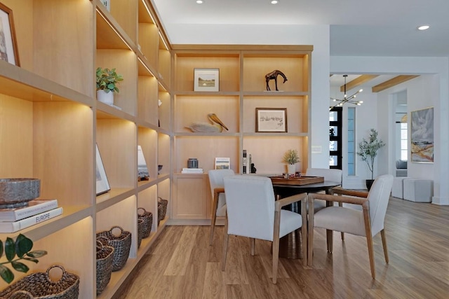 dining area featuring light hardwood / wood-style flooring and a notable chandelier