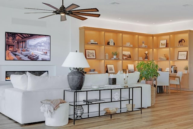 living room with ceiling fan and light wood-type flooring