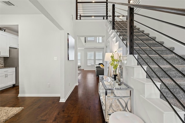 interior space with dark hardwood / wood-style floors and a high ceiling