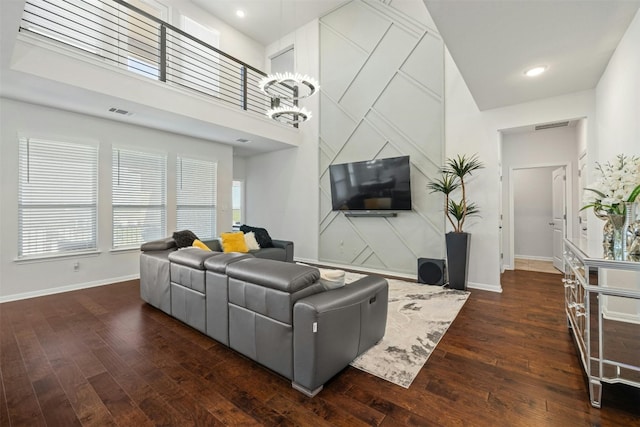 living room featuring a towering ceiling and dark wood-type flooring