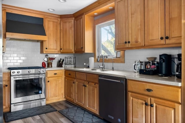 kitchen featuring premium range hood, dark wood-type flooring, sink, stainless steel range with gas cooktop, and black dishwasher