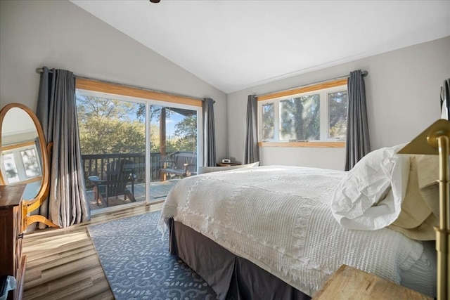 bedroom featuring hardwood / wood-style flooring, lofted ceiling, and access to exterior