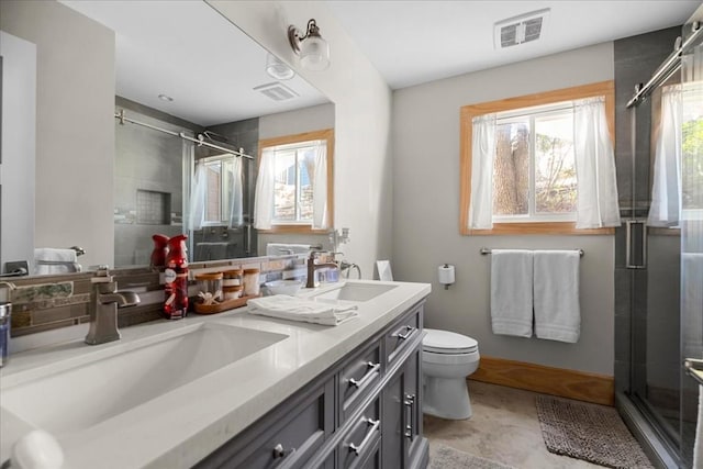 bathroom featuring vanity, toilet, and a shower with shower door