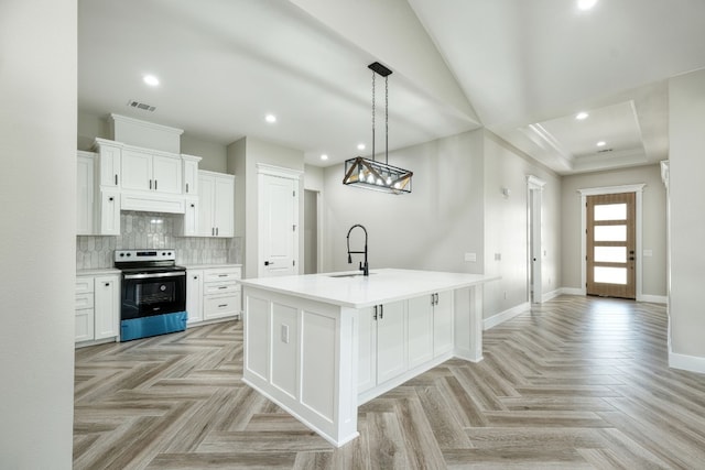 kitchen with stainless steel electric stove, sink, a center island with sink, and white cabinets