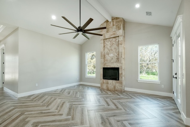 unfurnished living room with light parquet flooring, a fireplace, high vaulted ceiling, and a healthy amount of sunlight