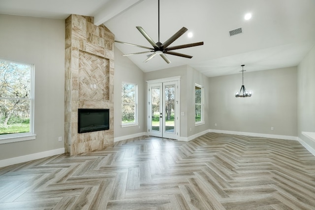 unfurnished living room featuring a healthy amount of sunlight, a fireplace, high vaulted ceiling, and beam ceiling