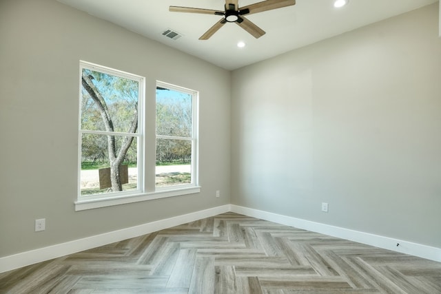 empty room with ceiling fan and light parquet flooring