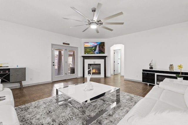 living room featuring ceiling fan and dark tile patterned floors