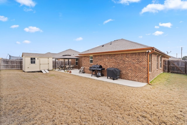 back of house with a gazebo, a storage shed, a yard, and a patio