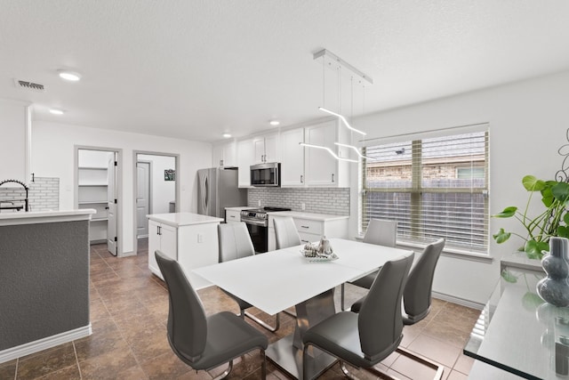 dining room with sink and a textured ceiling