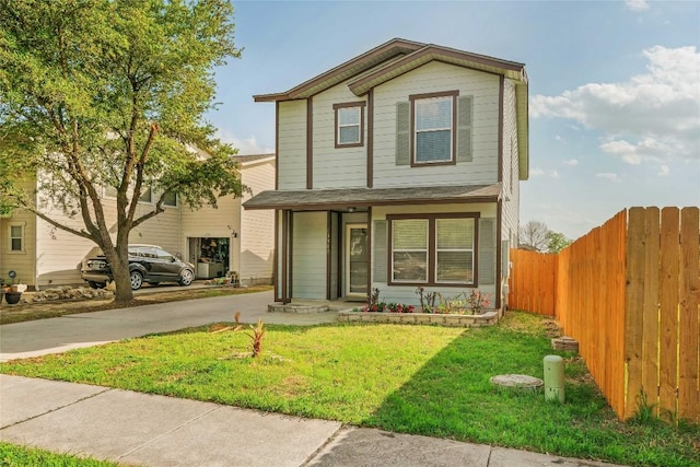 view of front of home with fence, driveway, and a front lawn