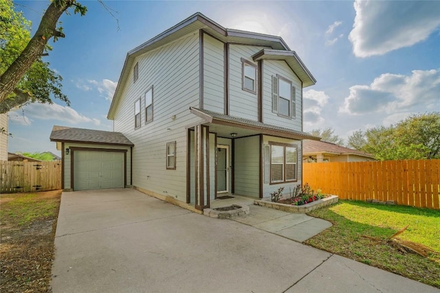 view of front of home featuring driveway, an attached garage, fence, and a front lawn