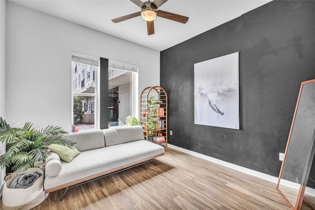 living room with wood-type flooring and ceiling fan