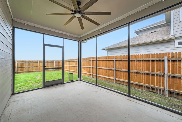 unfurnished sunroom featuring ceiling fan