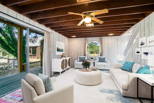 sunroom with ceiling fan and beam ceiling