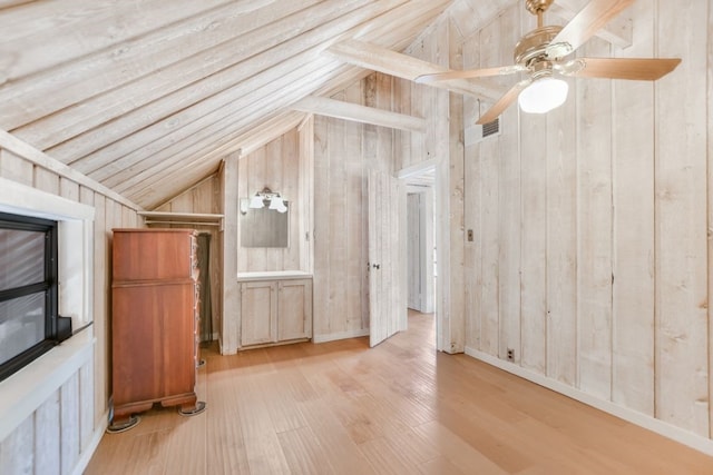 bonus room with lofted ceiling, wooden walls, and light wood-type flooring