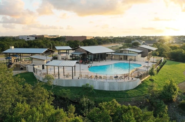 pool at dusk with a patio area