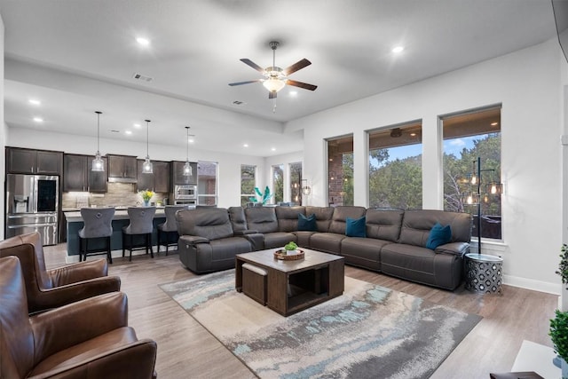 living room with ceiling fan and light hardwood / wood-style floors