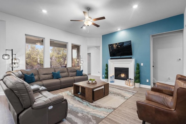 living room with ceiling fan and light hardwood / wood-style flooring