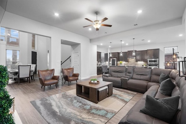 living room featuring light hardwood / wood-style floors and ceiling fan