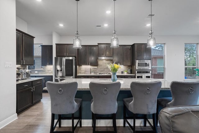 kitchen featuring pendant lighting, appliances with stainless steel finishes, and a kitchen island