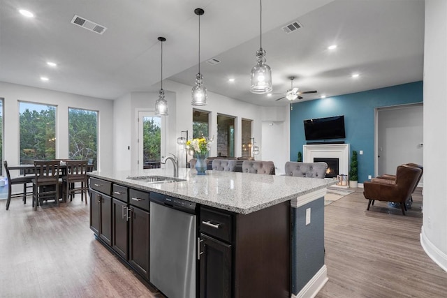 kitchen featuring pendant lighting, sink, stainless steel dishwasher, and a kitchen island with sink