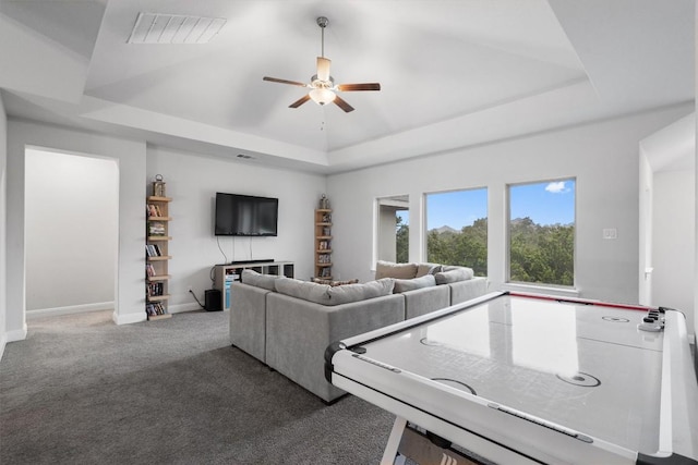 living room featuring carpet, ceiling fan, and a tray ceiling