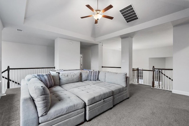 carpeted living room featuring ceiling fan and a tray ceiling