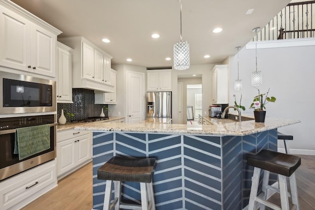 kitchen featuring white cabinetry, stainless steel appliances, and a breakfast bar