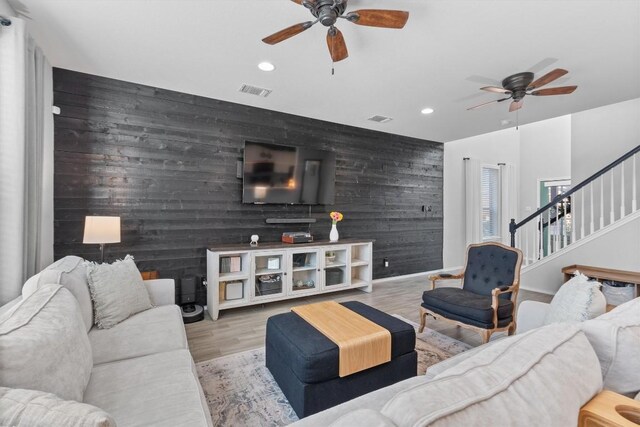 living room with light hardwood / wood-style floors and ceiling fan