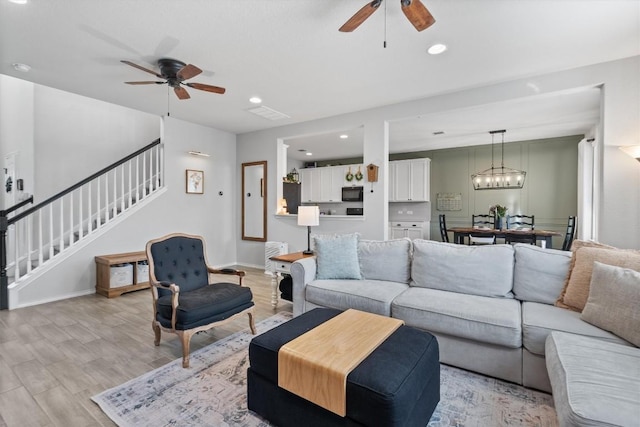 living room with ceiling fan and light hardwood / wood-style floors