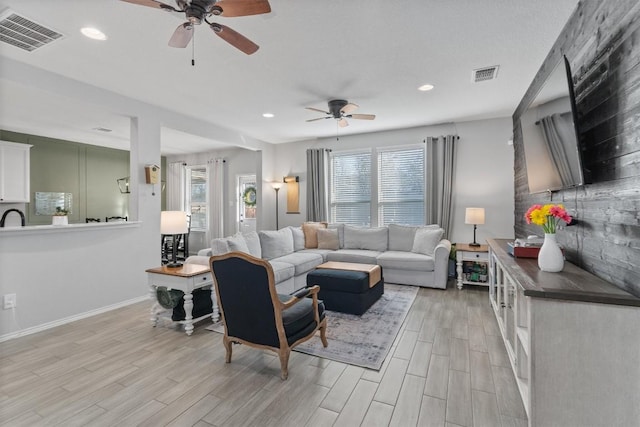 living room featuring ceiling fan and light wood-type flooring