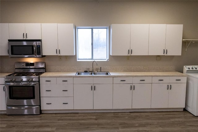 kitchen with white cabinetry, washer / dryer, sink, stainless steel appliances, and dark wood-type flooring