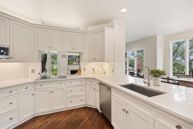 kitchen featuring sink, decorative backsplash, dark wood-type flooring, and appliances with stainless steel finishes