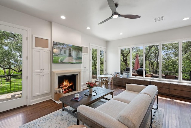 living room featuring ceiling fan and dark hardwood / wood-style flooring