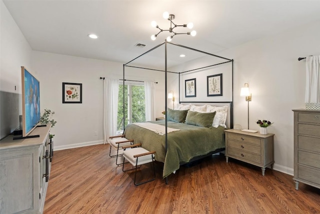 bedroom featuring hardwood / wood-style floors and a chandelier