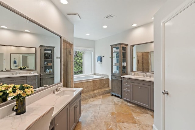 bathroom featuring vanity and tiled bath