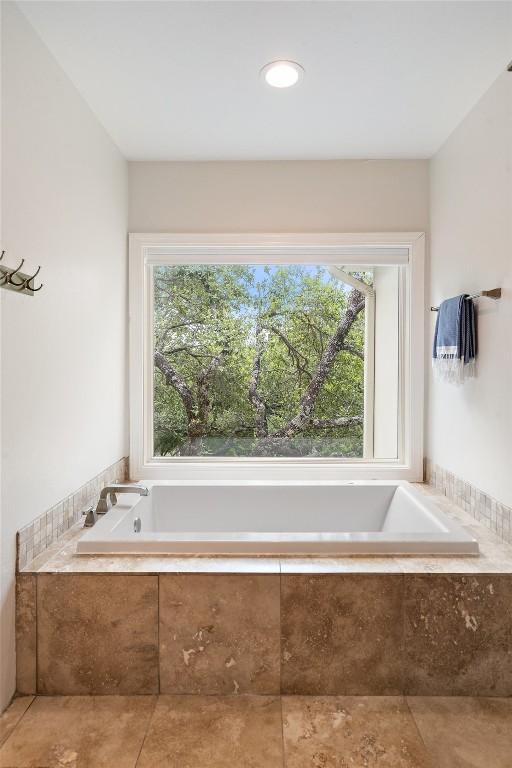 bathroom featuring tiled bath and tile patterned flooring