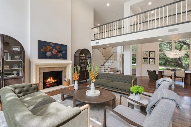 living room featuring a high ceiling, wood-type flooring, and a fireplace