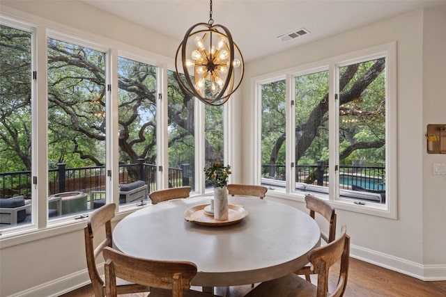 dining space featuring hardwood / wood-style flooring and an inviting chandelier